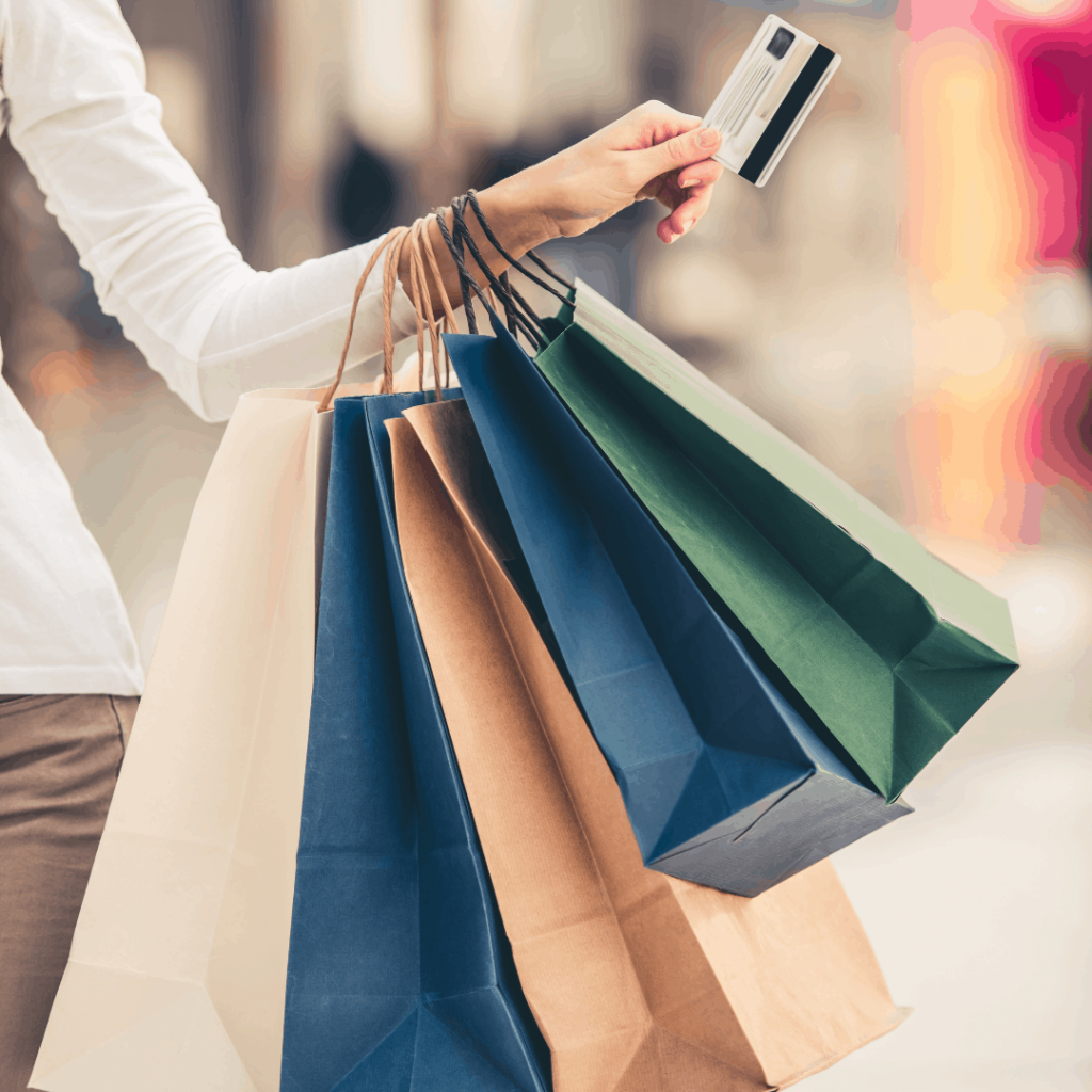 A woman overspending with a credit card and shopping bags