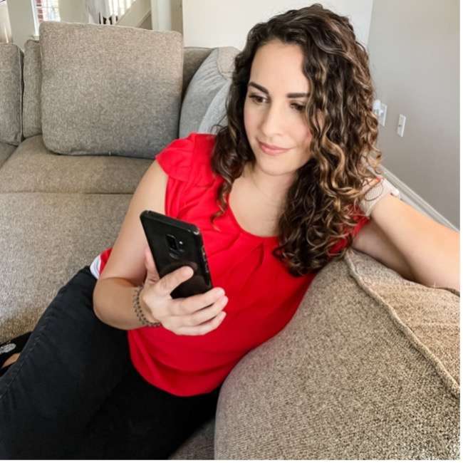 Woman sitting on sofa looking at phone
