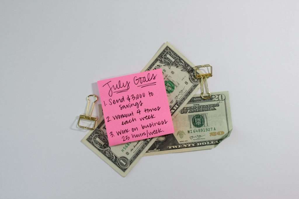 Cash, money clips, and a post-it note with goals