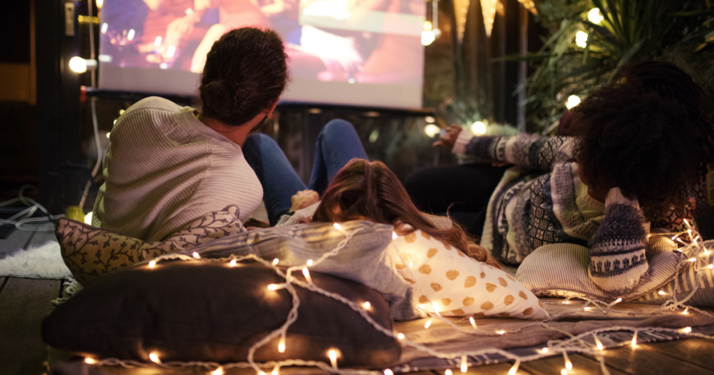 3 friends watching a movie together on the floor